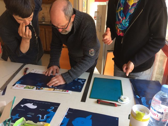 photo des bénévoles d'idéographik travaillant sur les maquettes du livre Petite Feuille rêve de Grand large