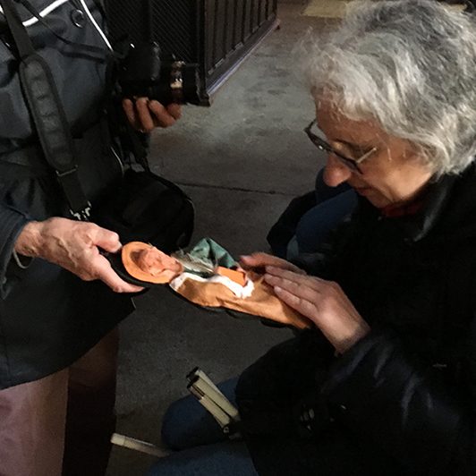 personne découvrant les sculptures représentant les Saints sur les vitraux.