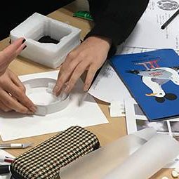 Des élèves fabriquent une maquette tactile d'un plan de localisation de l'espace du spectacle.