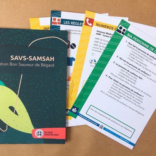 FONDATION BON SAUVEUR livret d'accueil de la Maison d'accueil spécialisée, le foyer d'accueil médicalisé, le SAVS SAMSAH et le foyer de vie. Sur la photo on voit une chemise et à droite des exemples de fiches synthétiques.