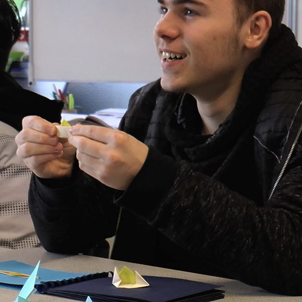 Jeune de 3e segpa heureux d'avoir réussi à plier un bateau