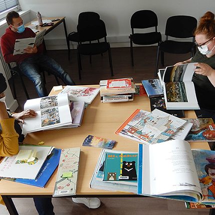 groupe de travail, plusieurs personnes découvrent, parcours les livres disposés sur une table
