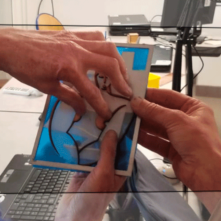 IMAGE TACTILE ATELIER exploration de l'œuvre de Marcelle Cahn par une personne non-voyante, aveugle. L'œuvre est composée de 3 plans, la femme, le bateau et le paquebot. Chaque plan peut être pris dans les mains et parcouru. Les matériaux donne des éléments de compréhension sur l'esthétique de chaque objet : le cuire pour la femme, le papier pour la légerté du voilier, le métal pour le paquebot