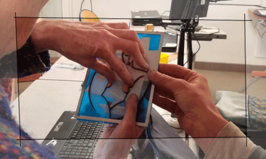 IMAGE TACTILE ATELIER exploration de l'œuvre de Marcelle Cahn par une personne non-voyante, aveugle. L'œuvre est composée de 3 plans, la femme, le bateau et le paquebot. Chaque plan peut être pris dans les mains et parcouru. Les matériaux donne des éléments de compréhension sur l'esthétique de chaque objet : le cuire pour la femme, le papier pour la légerté du voilier, le métal pour le paquebot